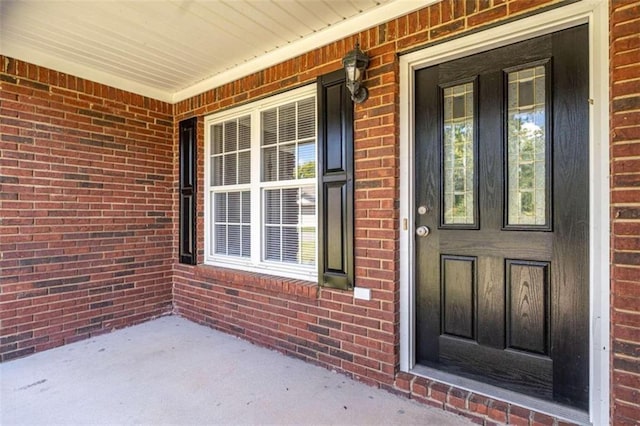 view of exterior entry featuring covered porch