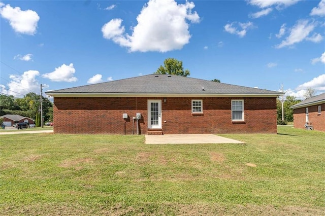 back of house with a yard and a patio