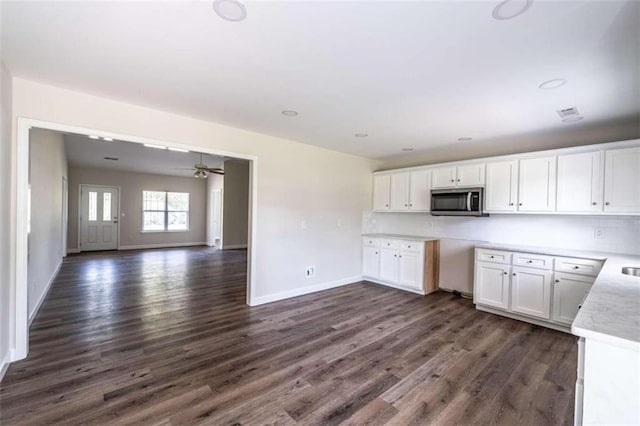 kitchen with ceiling fan, dark hardwood / wood-style floors, and white cabinetry