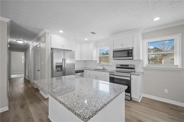 kitchen featuring visible vents, stainless steel appliances, decorative backsplash, and a sink