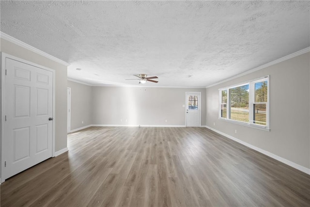 unfurnished room featuring crown molding, wood finished floors, baseboards, and ceiling fan