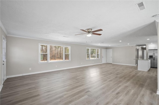 unfurnished living room with light wood-type flooring, visible vents, a ceiling fan, and crown molding