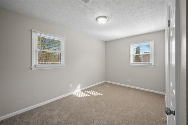 unfurnished room with baseboards, carpet, and a textured ceiling