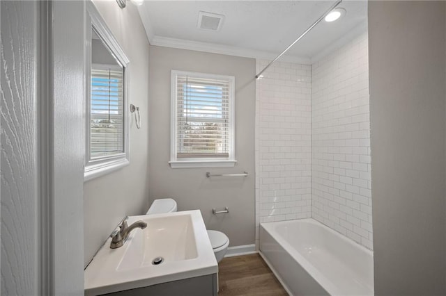 full bathroom with wood finished floors, baseboards, visible vents, ornamental molding, and toilet