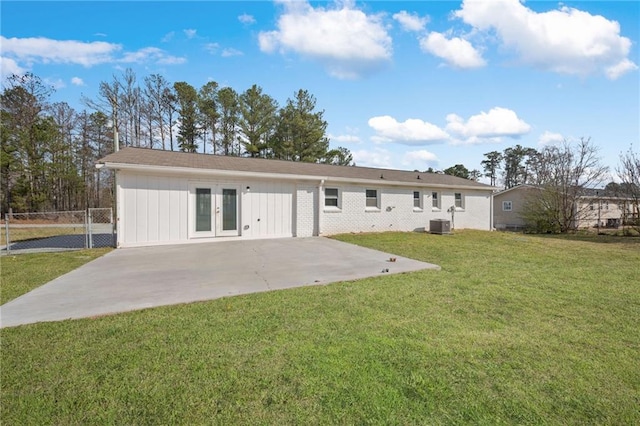 rear view of property featuring a lawn, fence, french doors, central AC unit, and a patio area