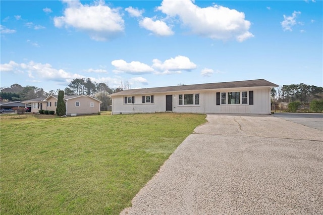 single story home featuring concrete driveway and a front lawn