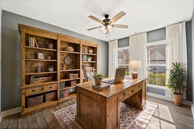 office area featuring baseboards, wood-type flooring, and ceiling fan