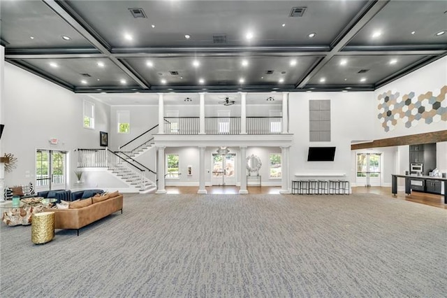 living room with coffered ceiling, a towering ceiling, and beamed ceiling