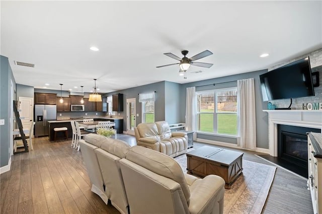 living room featuring ceiling fan and dark hardwood / wood-style flooring