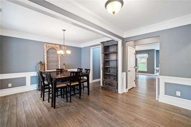 dining area featuring an inviting chandelier, crown molding, and dark hardwood / wood-style floors