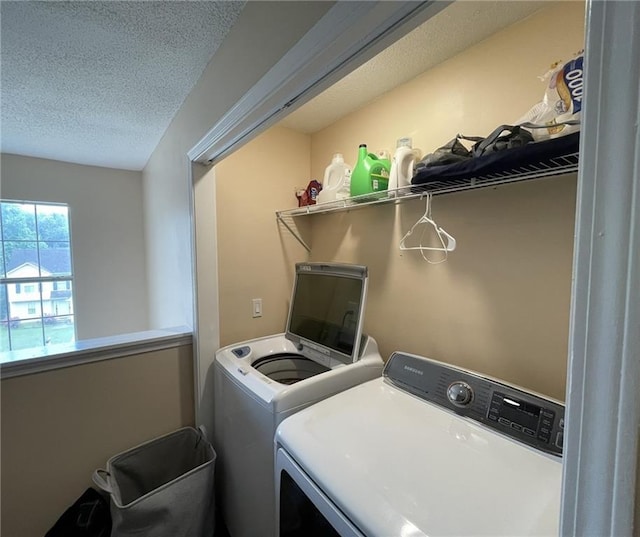 laundry room with washer and dryer and a textured ceiling