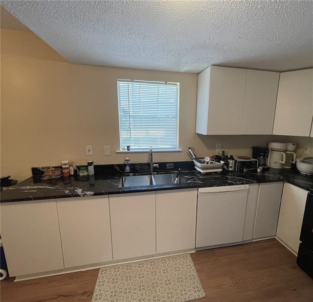 kitchen featuring a sink, white dishwasher, wood finished floors, white cabinetry, and a textured ceiling