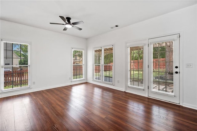 spare room featuring wood finished floors, a ceiling fan, and baseboards