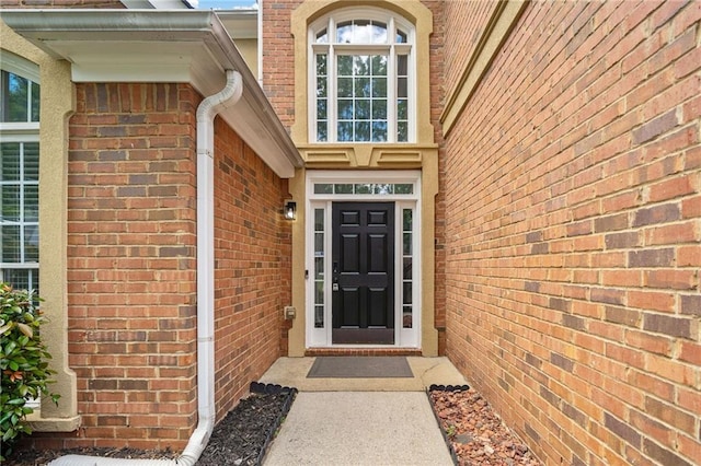 view of exterior entry featuring brick siding