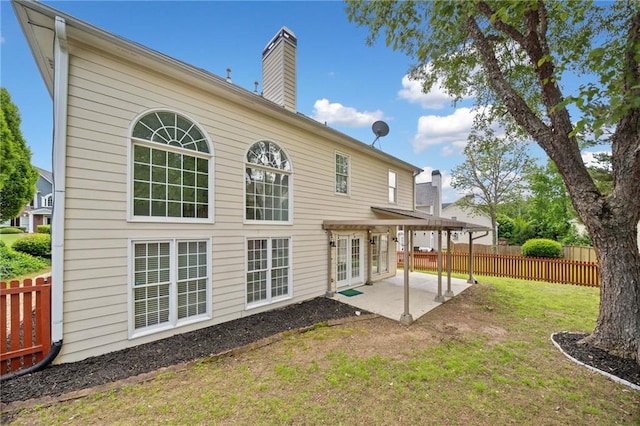 back of property with a chimney, a patio area, and french doors