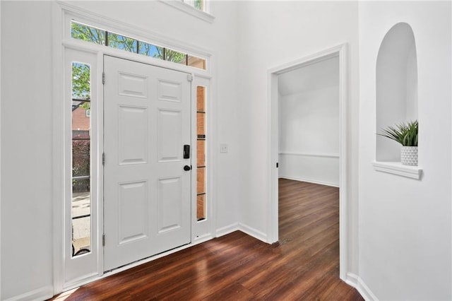 entrance foyer featuring dark wood finished floors and baseboards