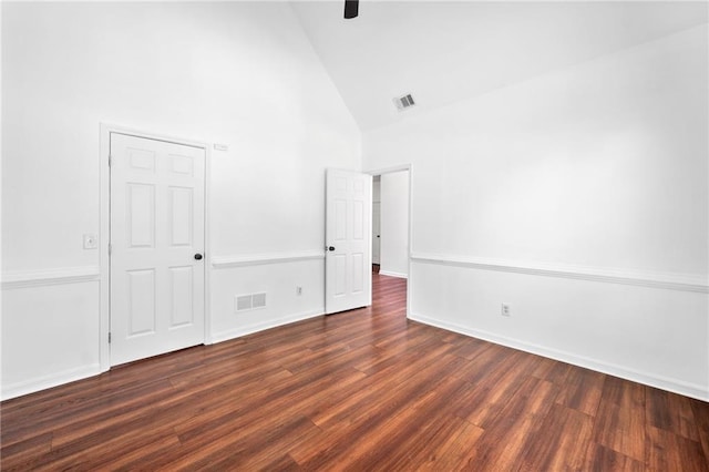 unfurnished bedroom with high vaulted ceiling, dark wood-style flooring, a ceiling fan, and baseboards