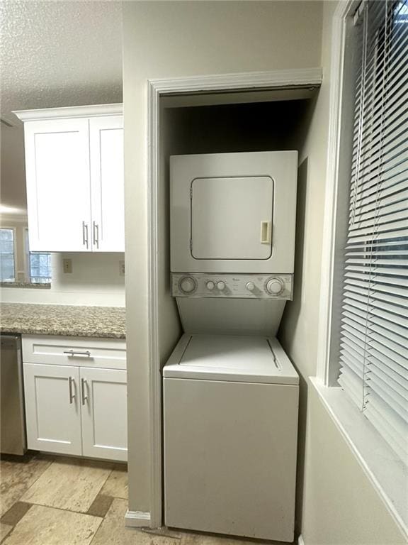 clothes washing area with laundry area and stacked washing maching and dryer