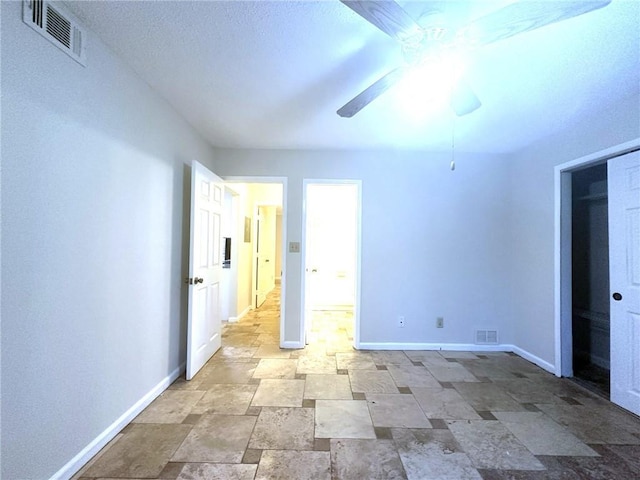 unfurnished bedroom featuring baseboards, visible vents, and stone finish flooring