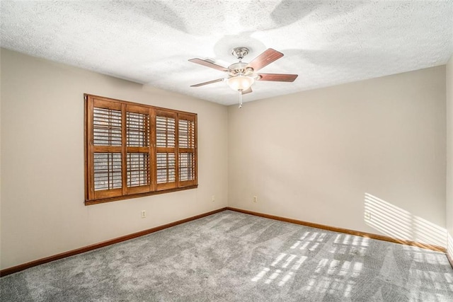 carpeted empty room featuring a textured ceiling, a ceiling fan, and baseboards