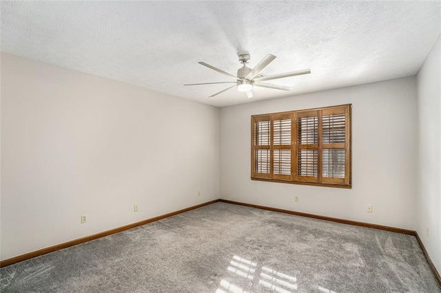 carpeted spare room with a ceiling fan, a textured ceiling, and baseboards