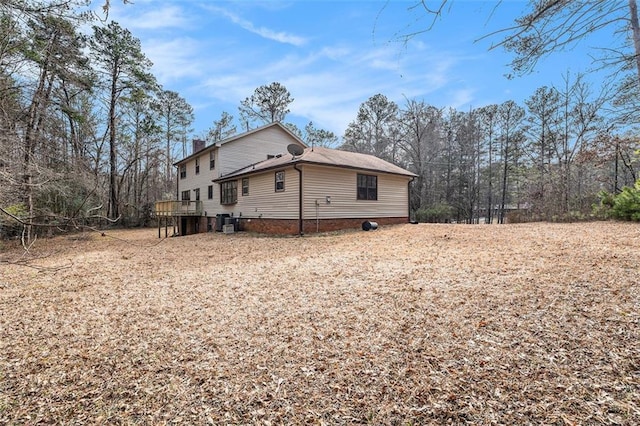 view of home's exterior with a deck, central AC, and a chimney