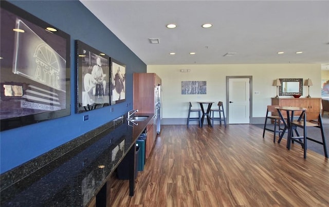 interior space featuring recessed lighting, dark wood finished floors, a sink, and baseboards