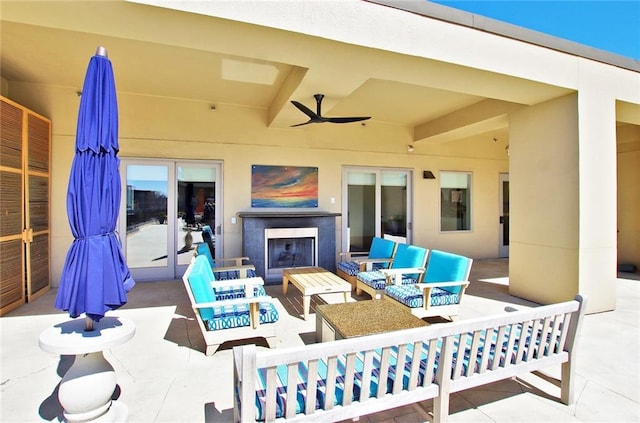 view of patio / terrace featuring an outdoor living space with a fireplace and ceiling fan