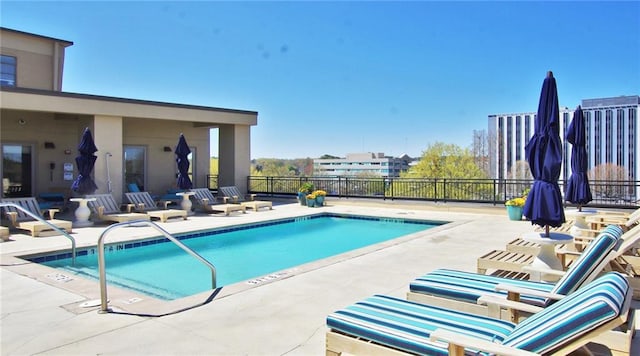 community pool with a patio area and fence