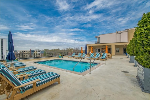 community pool featuring a patio and fence