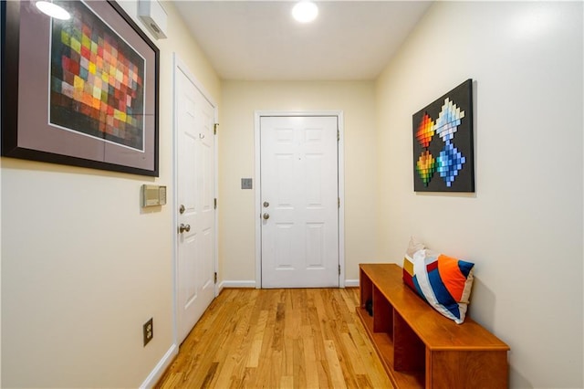 doorway with light wood-type flooring and baseboards