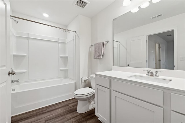 full bathroom with washtub / shower combination, vanity, hardwood / wood-style flooring, and toilet