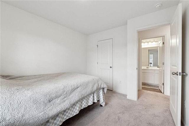 bedroom featuring light colored carpet and ensuite bath