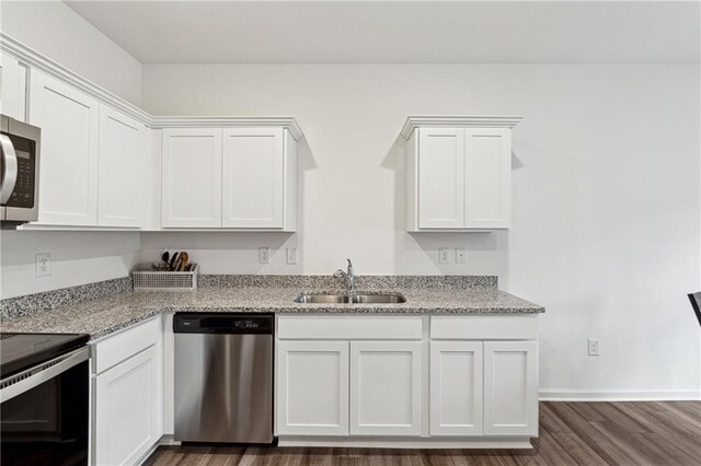 kitchen featuring white cabinets, appliances with stainless steel finishes, light stone counters, and sink