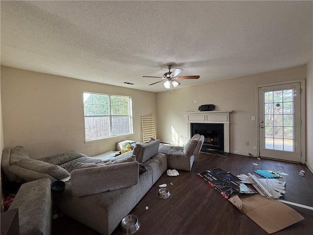 2625 Thunder Basin Way, Douglasville, GA 30135 - living room with visible vents, a fireplace with raised hearth, a ceiling fan, a textured ceiling, and wood finished floors