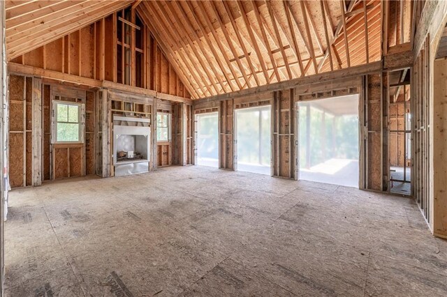 unfurnished living room with high vaulted ceiling