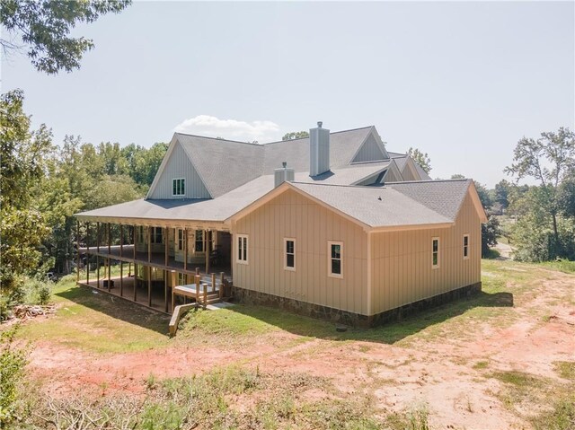 back of house featuring a lawn and a wooden deck