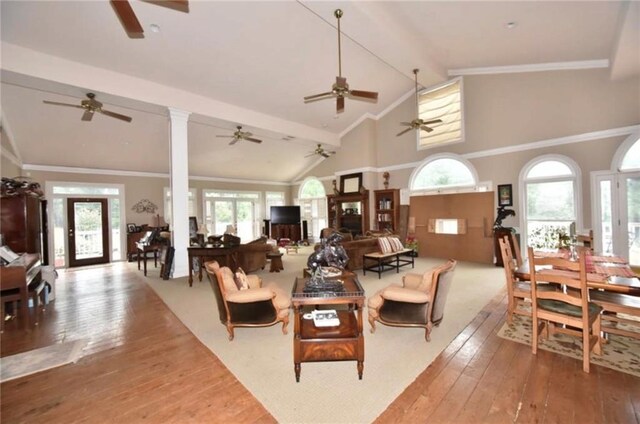 living room featuring beamed ceiling, light wood-type flooring, high vaulted ceiling, and ornate columns