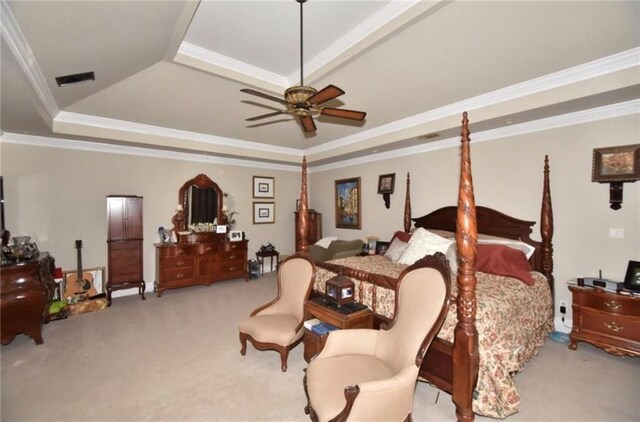 bedroom with ceiling fan, a raised ceiling, light colored carpet, and crown molding