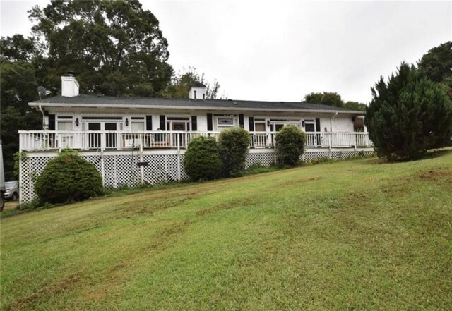 view of front of house featuring a front lawn and a deck