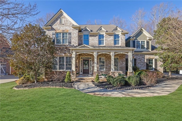 view of front facade featuring covered porch, brick siding, and a front lawn