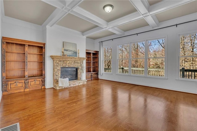 unfurnished living room with visible vents, coffered ceiling, wood finished floors, beamed ceiling, and a fireplace