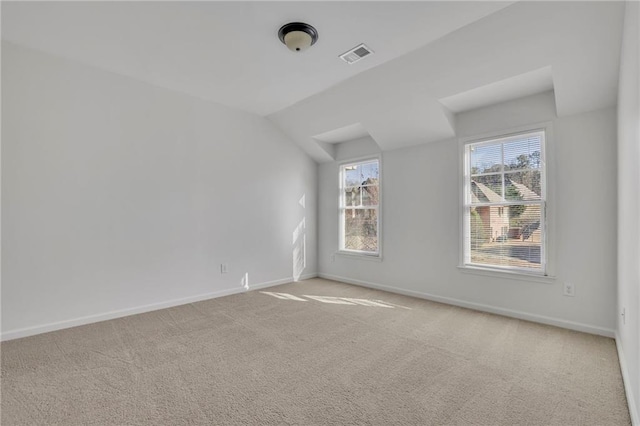 interior space featuring lofted ceiling, carpet, visible vents, and baseboards