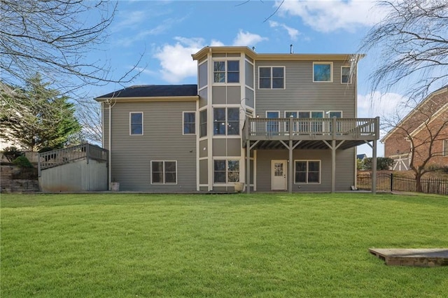 rear view of house with fence, a deck, and a yard