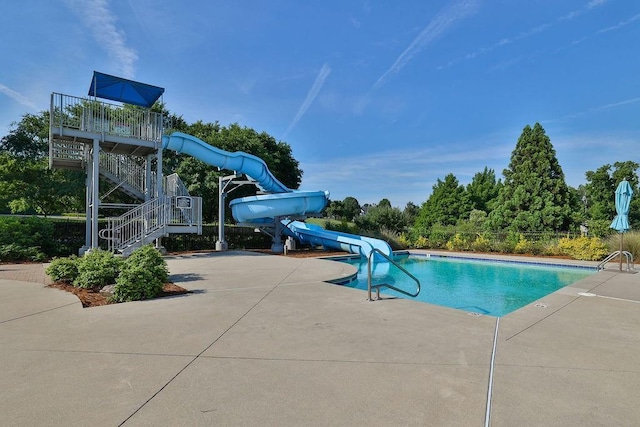 community pool with a water slide, a patio, and stairs