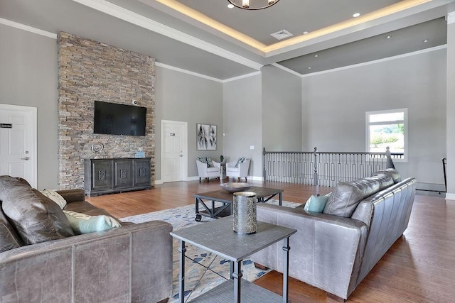 living room with ornamental molding, visible vents, and wood finished floors