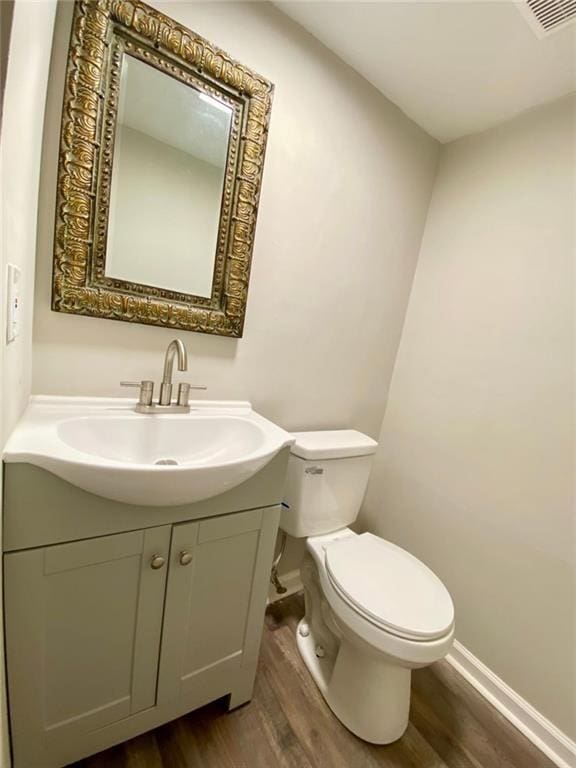 bathroom featuring vanity, toilet, and wood-type flooring