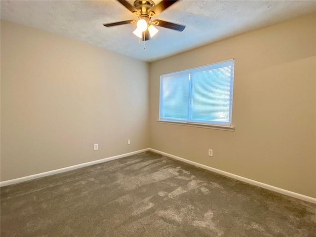 empty room with ceiling fan and dark colored carpet