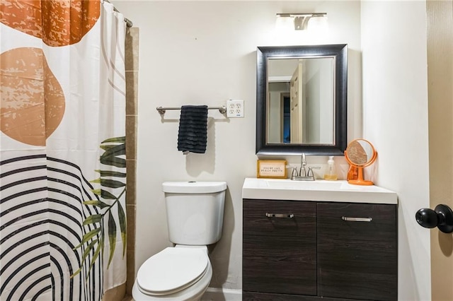 bathroom featuring vanity, curtained shower, and toilet