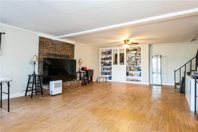 living room with hardwood / wood-style flooring, ceiling fan, and built in shelves